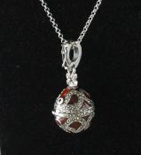 A SILVER AND ENAMEL MARCASITE EGG LOCKET on a chain.
