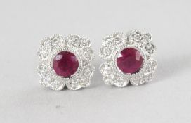 A PAIR OF 18CT WHITE GOLD VINTAGE FLOWER SHAPED RUBY (0.62cts) AND DIAMOND (0.14cts) EARRINGS.