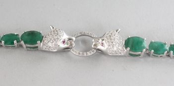 A CARTIER DESIGN SILVER, EMERALD SET AND PANTHER HEAD BRACELET.