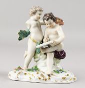 A 19TH CENTURY MEISSEN GROUP OF TWO PUTTI, Scribe. Cross swords mark in blue. 4.25ins high.