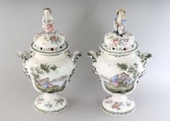 A GOOD PAIR OF FAIENCE VASES AND COVERS painted with figures, scrolls and flowers, the lids with a