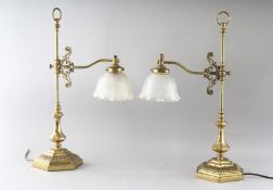 A GOOD PAIR OF HEAVY BRASS DESK LAMPS with glass shades on heavy brass bases. 24ins high.