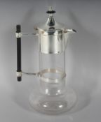 A CHRISTOPHER DRESSER DESIGN PLAIN GLASS CLARET JUG with plated mounts. 11ins high.