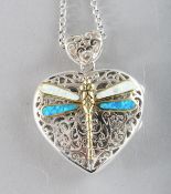 A SILVER FILIGREE DRAGONFLY ENAMEL HEART SHAPED LOCKET on a chain.