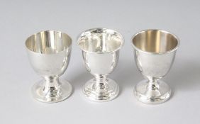 THREE SILVER EGG CUPS.