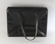 A LARGE BLACK PATENT BAG.
