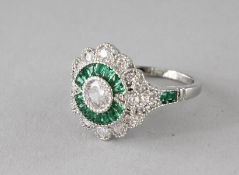 A SILVER FAUX EMERALD ART DECO DESIGN RING.