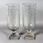 A PAIR OF SLICE CUT CIRCULAR GLASS STORM LAMPS on square stepped bases. 16ins high.