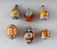 SIX AMBER AND SILVER PENDANTS.