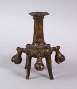 AN ISLAMIC BRONZE CANDLESTICK OR JOSS STICK HOLDER, on four feet with 5 ringing bells, 10cm high