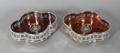 A PAIR OF SHAPED FAUX TORTOISESHELL WINE COASTERS.