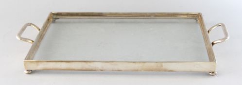 A TWO-HANDLED GLASS TEA TRAY with glass bottom. 17ins long.