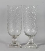 A SMALL PAIR OF CUT GLASS STORM LAMPS on square bases. 13.5ins high.