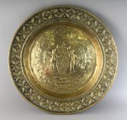 AN 18TH CENTURY BRASS CIRCULAR ALMS DISH repousse with figures carrying grapes. 17.5ins diameter.