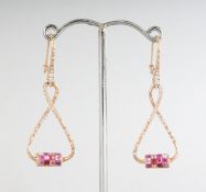 A PAIR OF 18CT ROSE GOLD DROP TWIST PINK SAPPHIRE (1.80cts) AND DIAMOND (0.49cts) EARRINGS.