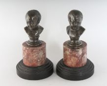A SMALL PAIR OF GRAND TOUR BRONZE BUSTS on marble bases. 5ins high.