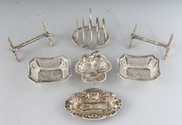 A PAIR OF SILVER KNIFE RESTS, SMALL TOAST RACK AND THREE SMALL SILVER DISHES (6).
