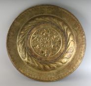 AN 18TH CENTURY BRASS CIRCULAR ALMS DISH repousse with a rosette. 16.5ins diameter.