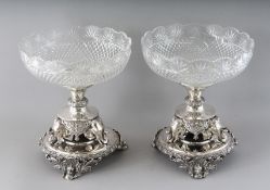 A PAIR OF PLATED CENTREPIECES with circular cut glass bowls on a stand with three elephant mounts,