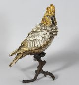 A VIENNA PAINTED COLD CAST PARROT ON A TREE STUMP. 12ins high.