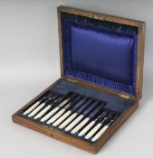 AN OAK CASE OF SIX SILVER AND MOTHER-OF-PEARL HANDLED FRUIT KNIVES. Sheffield 1919-1930. Maker: