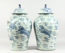 A PAIR OF 20TH CENTURY CHINESE BLUE AND WHITE BALUSTER SHAPE TEMPLE JARS AND COVERS, painted with