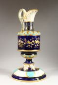 A CONTINENTAL PORCELAIN EWER, dark blue ground with floral and gilt decoration, on a matching stand.