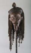 A CONWAY CARVED WOOD TRIBAL MASK with rope hair.