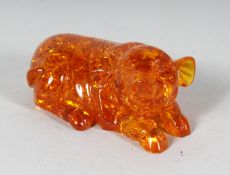 AN AMBER RECLINING PIG. 4ins long.