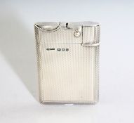 AN ASPREY ENGINE TURNED SILVER PETROL LIGHTER. London 1956.