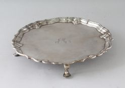 A GEORGE II PIECRUST SALVER on four pad feet. 10.5ins diameter. London 1737. Maker: HM. Weight