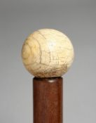 A GOOD WALKING CANE with carved mammoth handle. 33ins long.