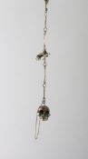 A BRASS SKULL SNUFF BOX on a chain.