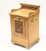 A VICTORIAN OAK COAL PURDONIUM, with carved decoration and brass handles. 2ft 2ins high.