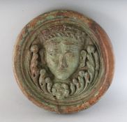 AN 18TH CENTURY CARVED WOOD ROUNDEL, carved with a head. 11.5ins diameter.