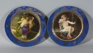 A PAIR OF CLASSICAL PLATES with blue borders. 10ins diameter.