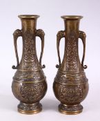 A SMALL PAIR OF 20TH CENTURY CHINESE BRONZE VASES, with animal form handles and incised decoration