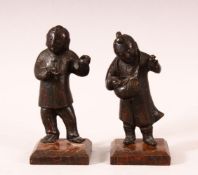 A PAIR OF SMALL CHINESE CAST BRONZE FIGURES OF YOUNG BOYS, holding items in their hand, showing
