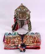 A BALOCHISTAN HEAD DRESS, adorned with coins, rings, beads etc. together with associated overshirt.