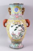 A GOOD LARGE FAMILLE ROSE BALUSTER SHAPE VASE, with coral coloured elephant head handles, painted