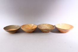 A GROUP OF FOUR EARLY CHINESE EARTHENWARE CIRCULAR BOWLS, various sizes.