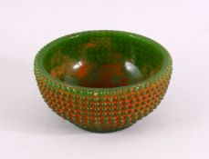 A GREEN JADITE CIRCULAR BOWL with beaded decoration all over, 11.5cm diameter.