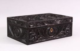 A CEYLONESE CARVED EBONY CASKET, with hinged lid, 26cm long.