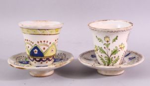 TWO ISLAMIC POTTERY CUPS AND SAUCERS, with floral and geometric decoration.