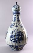 A LARGE KANGXI STYLE RIBBED PEAR-SHAPED BOTTLE VASE AND COVER, painted with panels of dragons,