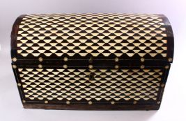 A LATE 19TH CENTURY EBONY DOMED TOP CASKET with bone inlaid geometric design, 62cm long, 40cm