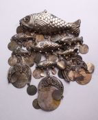 A LARGE EASTERN WHITE METAL PENDANT OR CHIME AS A GROUP OF FISH, suspended with Islamic coins,