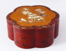 AN EARLY 20TH CENTURY JAPANESE LACQUER BOX AND COVER, of lobed form, the cover onlaid with carved