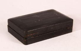 A JAPANESE INK BLOCK, carved with a dragon in a lacquer box, 15cm wide.