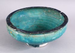 AN EARLY PERSIAN OTTOMAN TURQUOISE GLAZED POTTERY BOWL (repairs and restoration), 19cm diameter.